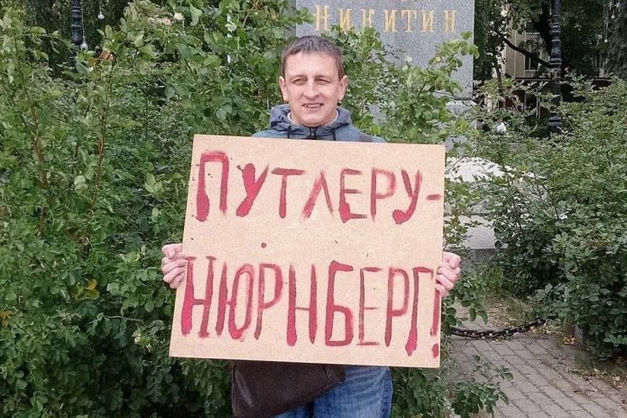 <em>Григорий Северин в одиночном пикете. За этот же плакат в январе 2021 года его <a href="https://cechyyzn---mekodxpr-bsccljbcrq-ez.a.run.app/express-news/2021/01/20/voronezhca-arestovali-iz-za-odinochnogo-piketa-v-podderzhku-navalnogo"><u>арестовали</u></a> на пять суток (ч. 8 ст. 20.2 КоАП РФ) / Фото: Свободные Люди Воронежа</em>